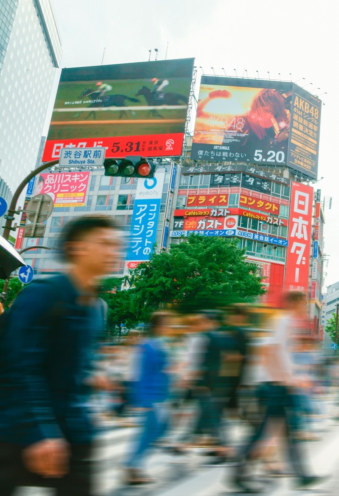 Busy street crossing with illuminated advertising signage